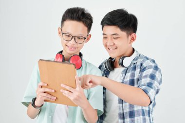 Heyecanlı Asyalı gençler tablet bilgisayarda yeni uygulamaları tartışıyorlar