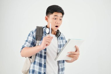 Denklemleri çözen ve cevapları kitapla yazan heyecanlı bir öğrenci.