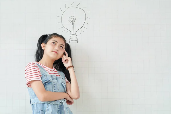 Pensive Teenage Asian Girl Standing White Wall Light Bulb Drawing — Stock Photo, Image