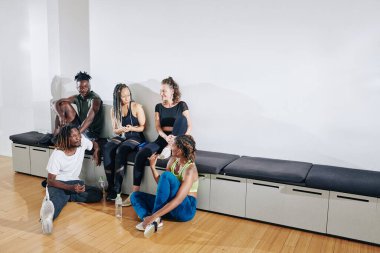 Stüdyoda çalıştıktan sonra performans ve dedikoduları tartışan çok ırklı genç dansçılar grubu.