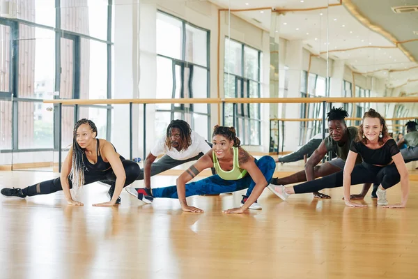 Улыбающиеся Танцоры Делают Половину Приседаний Размять Ноги Разогреться Перед Тренировкой — стоковое фото