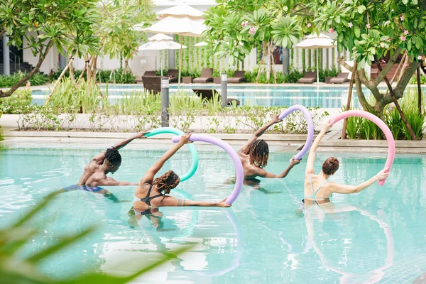 Grupo Jóvenes Activos Pie Piscina Con Fideos Flotantes Las Manos — Foto de Stock