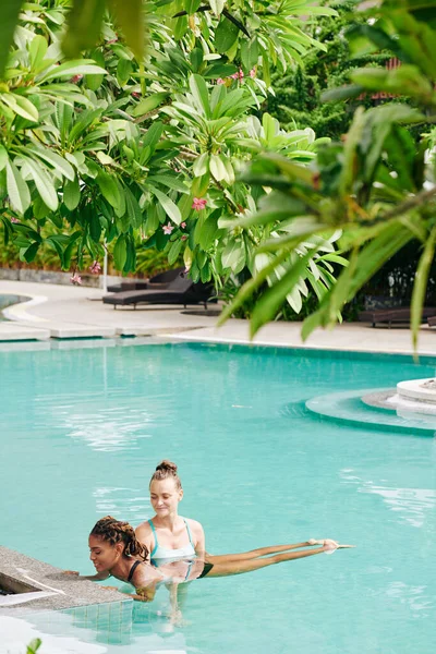 Hübsch Lächelnde Fitnesstrainerin Unterstützt Junge Frau Beim Training Schwimmbad — Stockfoto