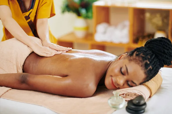 Sorrindo Jovem Mulher Negra Recebendo Relaxante Massagem Nas Costas Salão — Fotografia de Stock