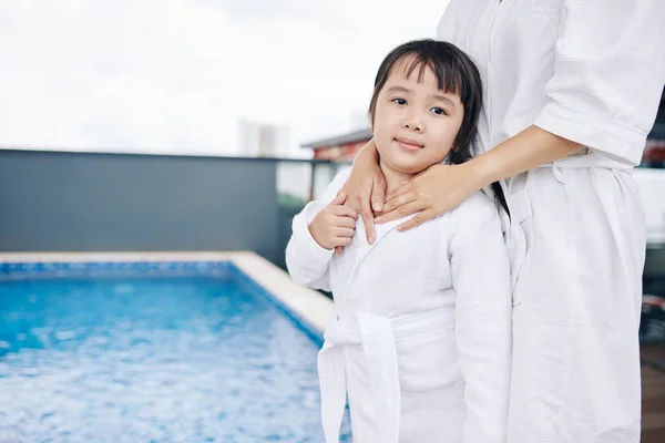 Matka Objímající Její Roztomilé Dcerušky Bílém Županu Když Stojí Bazénu — Stock fotografie