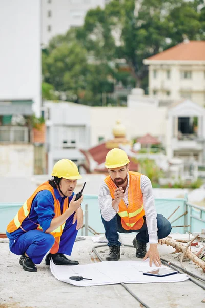 承包商通过对讲机控制建筑商工作时 总工程师检查施工计划 — 图库照片