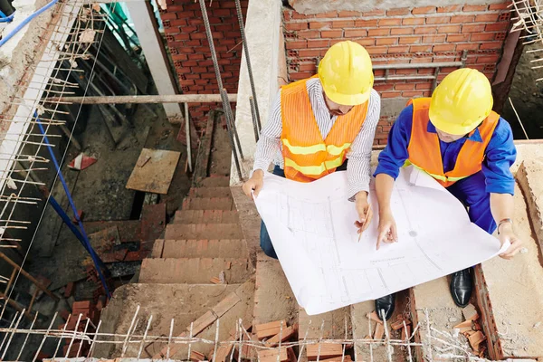 Byggnadsarbetare Som Sitter Trappor Inne Byggnaden Och Diskuterar Detaljer Ritningen — Stockfoto