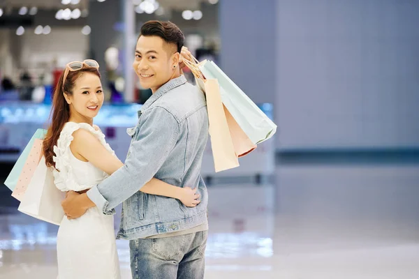 Retrato Joven Alegre Asiático Sosteniendo Bolsas Compras Abrazándose Volviéndose Atrás — Foto de Stock