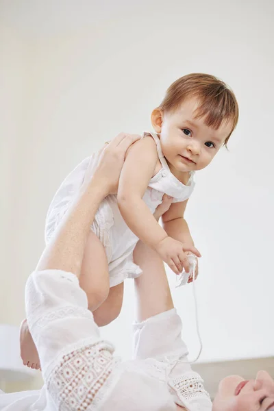 Jovem Mulher Levantando Sua Adorável Menina Olhando Para Câmera Quando — Fotografia de Stock