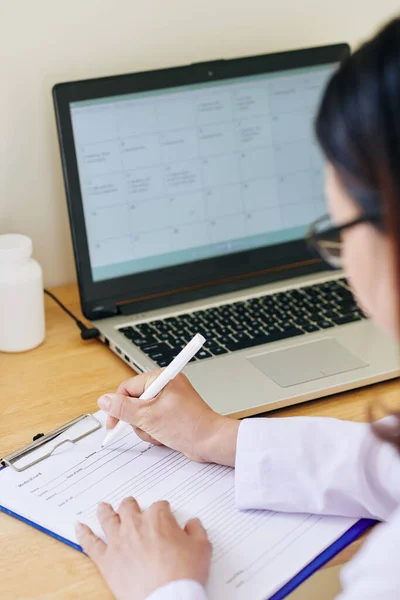 Médecin Féminin Assis Son Bureau Avec Ordinateur Portable Ouvert Remplissant — Photo