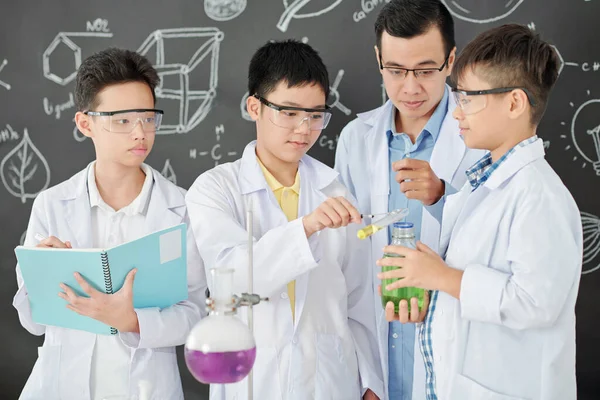 Insegnante Chimica Che Controlla Gli Studenti Delle Scuole Mescolando Liquidi — Foto Stock