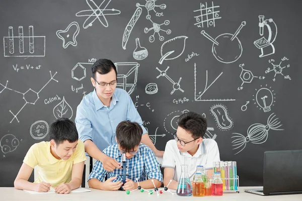 Aziatische Scheikunde Leraar Uitleggen Nieuwsgierige School Studenten Hoe Microscoop Gebruiken — Stockfoto