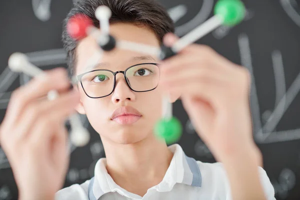 Intelligent Serious Asian Schoolboy Glasses Examining Plastic Model Chemical Element — Stock Photo, Image