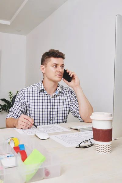 Ciddi Genç Tasarımcısı Ofis Masasında Oturuyor Müşteriyle Telefonda Konuşuyor Web — Stok fotoğraf