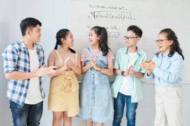 Mutlu Asyalı matematik öğretmeni ve öğrencileri zor denklemi çözdükten sonra alkışlıyorlar.