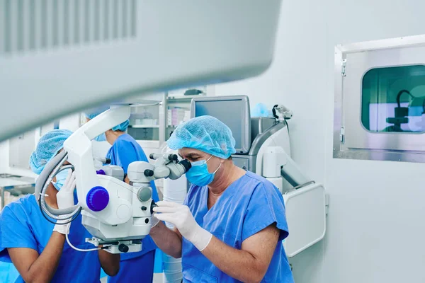 Olgun göz doktoru ve hemşire klinikte lazer görme düzeltmesi yapıyor.