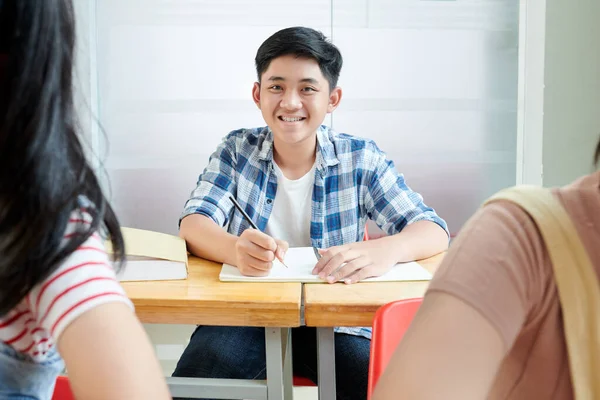 Rapaz Adolescente Positivo Sentado Mesa Sala Aula Escrevendo Livro Didático — Fotografia de Stock