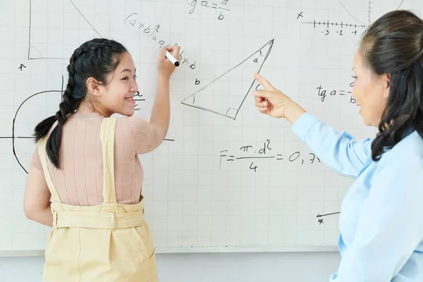 Lächelndes Asiatisches Schulmädchen Wendet Sich Beim Schreiben Von Gleichungen Auf — Stockfoto