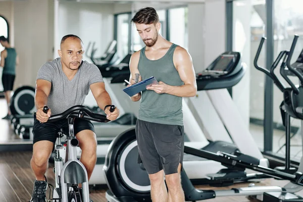 Fitness Trainer Schreibt Dokument Wenn Sein Klient Neues Cardio Workout — Stockfoto