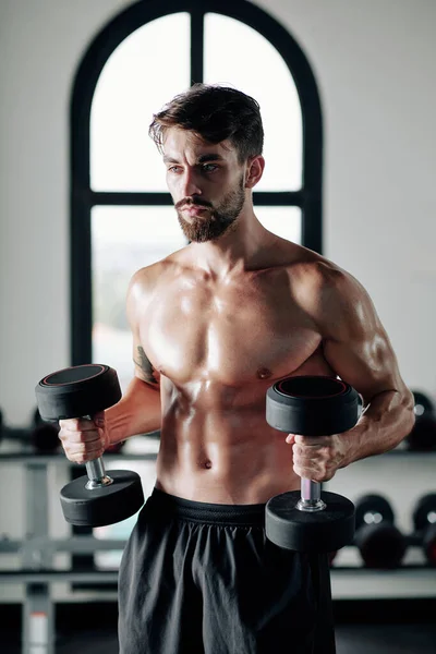 Fuerte Joven Sin Camisa Serio Haciendo Ejercicio Con Pesadas Mancuernas — Foto de Stock