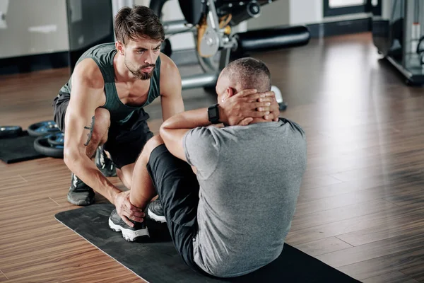 Frowning Serio Fitness Trainer Aiutare Uomo Facendo Sit Crunches Mat — Foto Stock