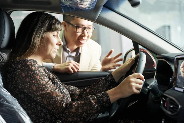 Mulher Bonita Sentada Salão Automóveis Ouvindo Gerente Explicando Algumas Funções — Fotografia de Stock