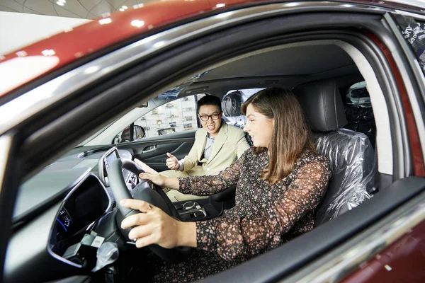 Jovem Mulher Testando Carro Novo Juntamente Com Vendedor Enquanto Eles — Fotografia de Stock