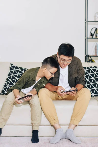 Nieuwsgierige Knappe Jongen Zoek Naar Smartphone Scherm Van Zijn Vader — Stockfoto