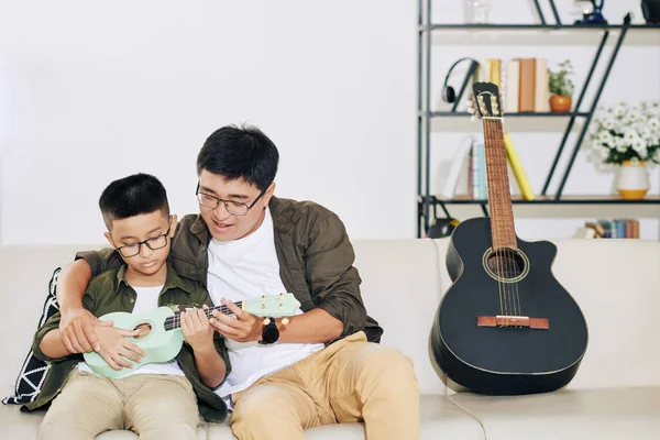 Vietnamita Uomo Insegnamento Suo Talento Preteen Figlio Giocare Ukulele Casa — Foto Stock