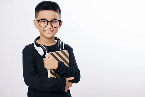 戴眼镜的积极的亚洲男孩举着书本 对着相机微笑 与白色隔离 — 图库照片