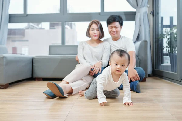 Gelukkig Knuffelen Ouders Zitten Vloer Kijken Naar Hun Kruipende Baby — Stockfoto