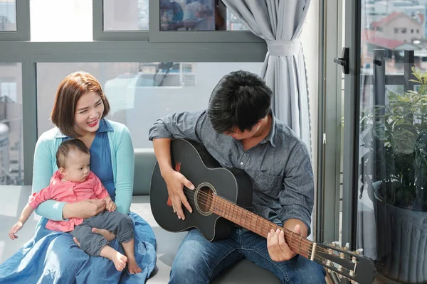 Jovem Tocando Guitarra Cantando Para Sua Esposa Uma Pequena Filha — Fotografia de Stock