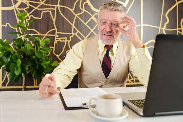 Senior Geschäftsmann Justiert Brille Und Liest Geschäftsvertrag Wenn Cafétisch Sitzt — Stockfoto