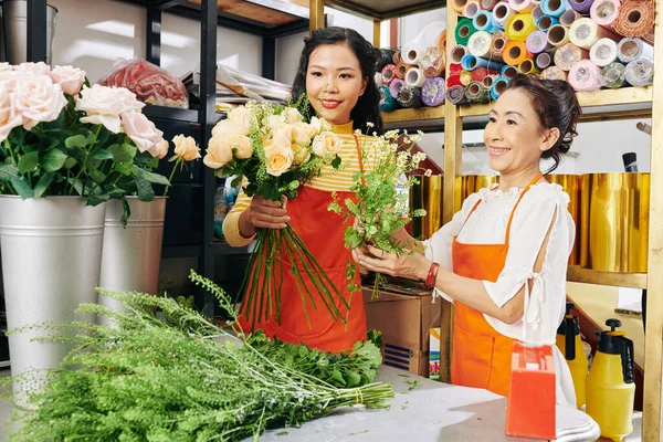 美しい花束の中で花を配置する方法初心者を教える経験豊富なシニア花屋 — ストック写真