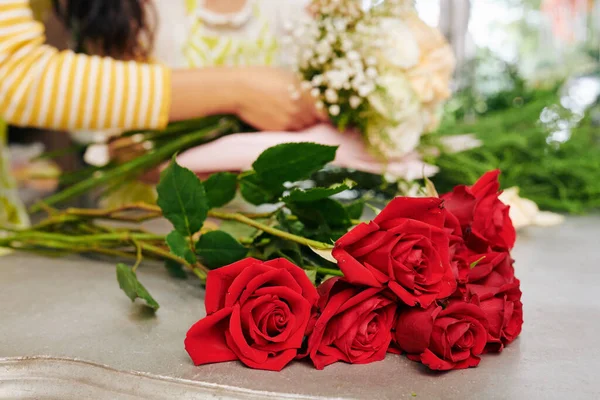 Прилавках Цветочного Магазина Свежие Красные Цветы Флористы Работают Заднем Плане — стоковое фото