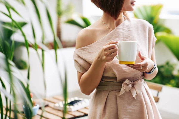 熱いコーヒーや紅茶の大きなマグカップで立っている若い女性の作物のイメージ — ストック写真