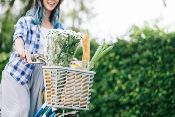 一篮鲜花和杂货在公园骑自行车的兴奋的年轻亚洲女人的剪影 — 图库照片