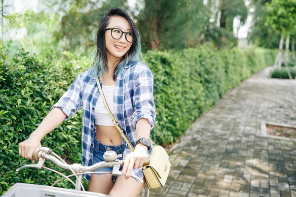 幸せなかなり若いです中国人女性でガラス乗馬自転車で市公園 — ストック写真