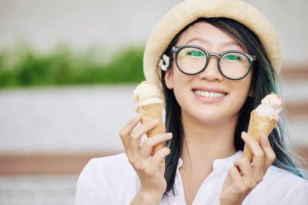 안경을 맛있는 아이스크림 원추형으로 포즈를 취하는 매력적 미소짓는 여자의 — 스톡 사진