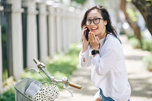 Portret Szczęśliwej Chińskiej Kobiety Siedzącej Rowerze Rozmawiającej Przez Telefon Przyjacielem — Zdjęcie stockowe