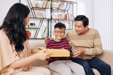 Gülümseyen çocuk ailesinden doğum günü hediyesi aldığı için heyecanlı.