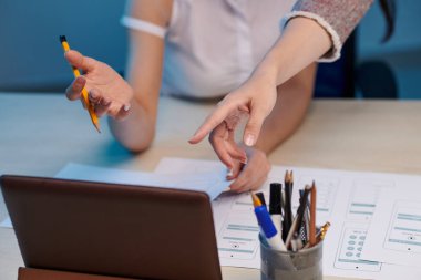 UX tasarımcısıyla uygulama arayüzü düzenini tartışırken iş kadınlarının tablet bilgisayarının ekranını gösteren yakın plan resmi