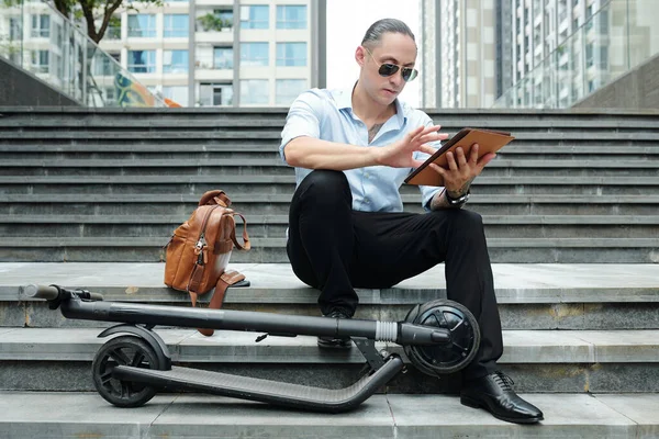 Jovem Empreendedor Sério Sentado Passos Lado Scooter Usando Aplicativo Tablet — Fotografia de Stock