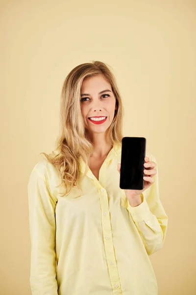 Retrato Joven Rubia Alegre Mostrando Teléfono Inteligente Aislado Amarillo — Foto de Stock