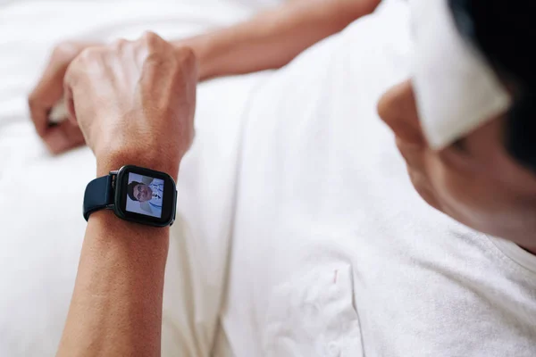 Dojrzały Mężczyzna Pomocą Aplikacji Smartwatch Aby Uzyskać Konsultacje Lekarzem — Zdjęcie stockowe