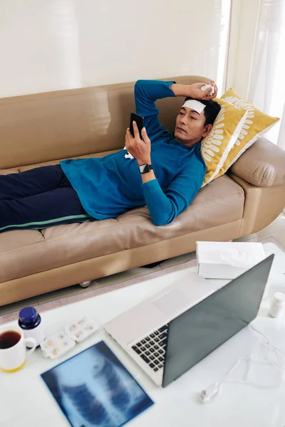 Hombre Con Parche Fiebre Refrescante Frente Acostado Sofá Las Recomendaciones — Foto de Stock