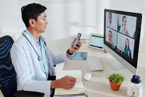 Serious Middle Aged Asian Doctor Having Online Conference Colleagues Taking — Stock Photo, Image