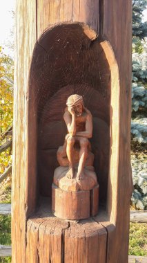 Üzgün adam için örümcek ağı içinde kaplı bir şey bekleyen rock oturur. Örümcek ağı sıkılmış adam ahşap heykel.