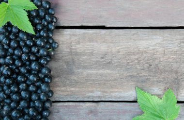 Ahşap arka plan üzerinde siyah frenk üzümü meyveler