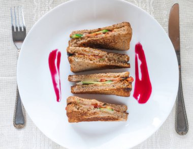 Üçgen şekli sandviç. Peynir, salatalık, fesleğen ve domates ile.